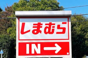 Sign with Japanese text and "IN" with an arrow indicating an entrance