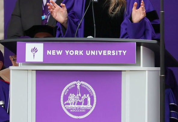 Taylor Swift speaking at a podium during NYU graduation ceremony