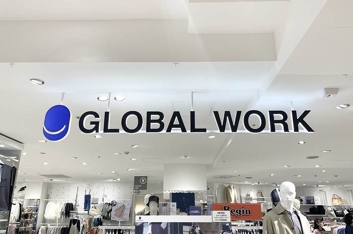 Sign for "GLOBAL WORK" above clothing store interior with mannequins and apparel displays
