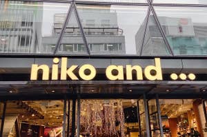 Storefront of "niko and..." with clothing and items visible through glass façade