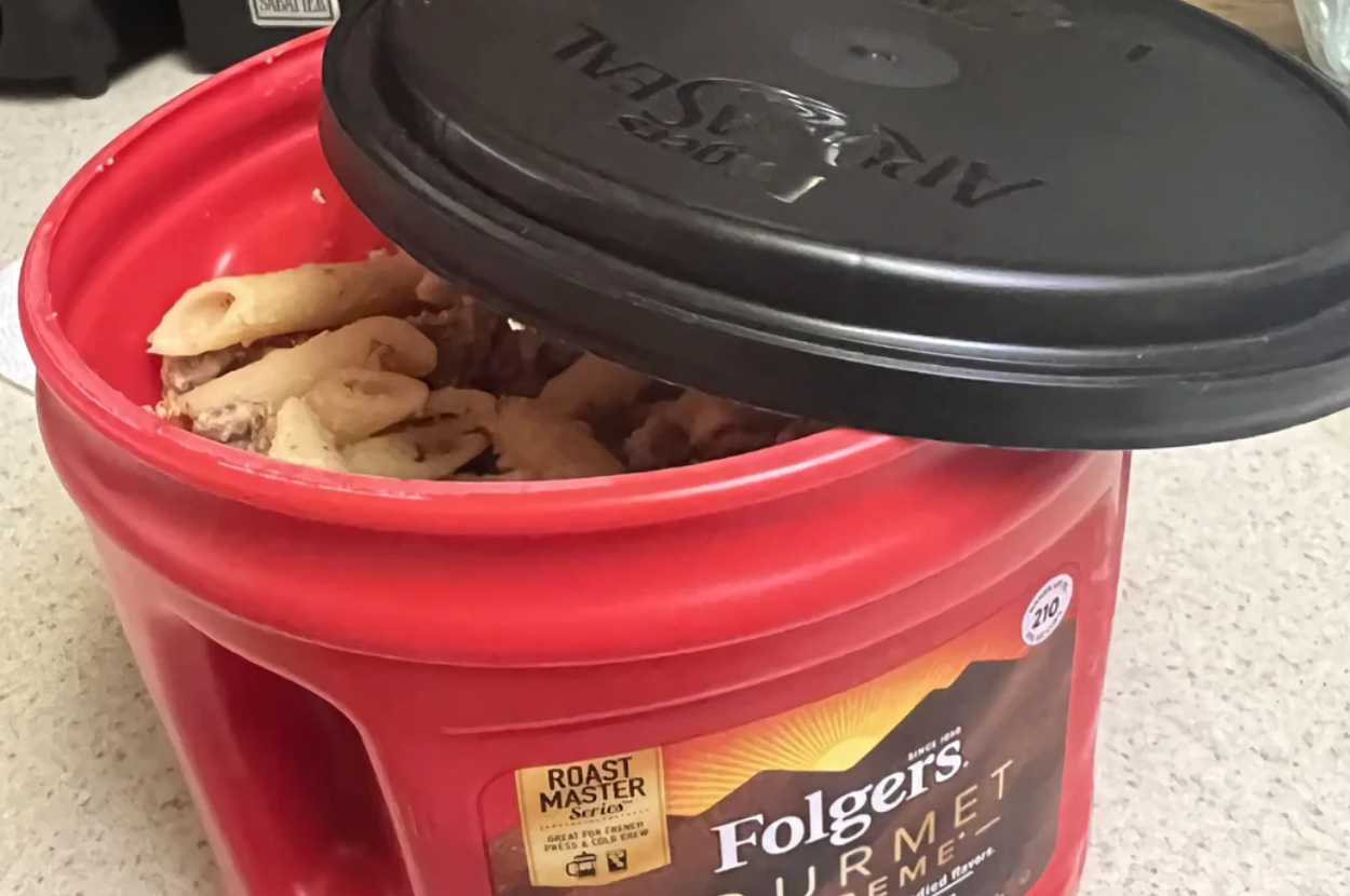 A Folgers coffee container repurposed to hold kitchen food waste for composting, illustrating waste reduction practices
