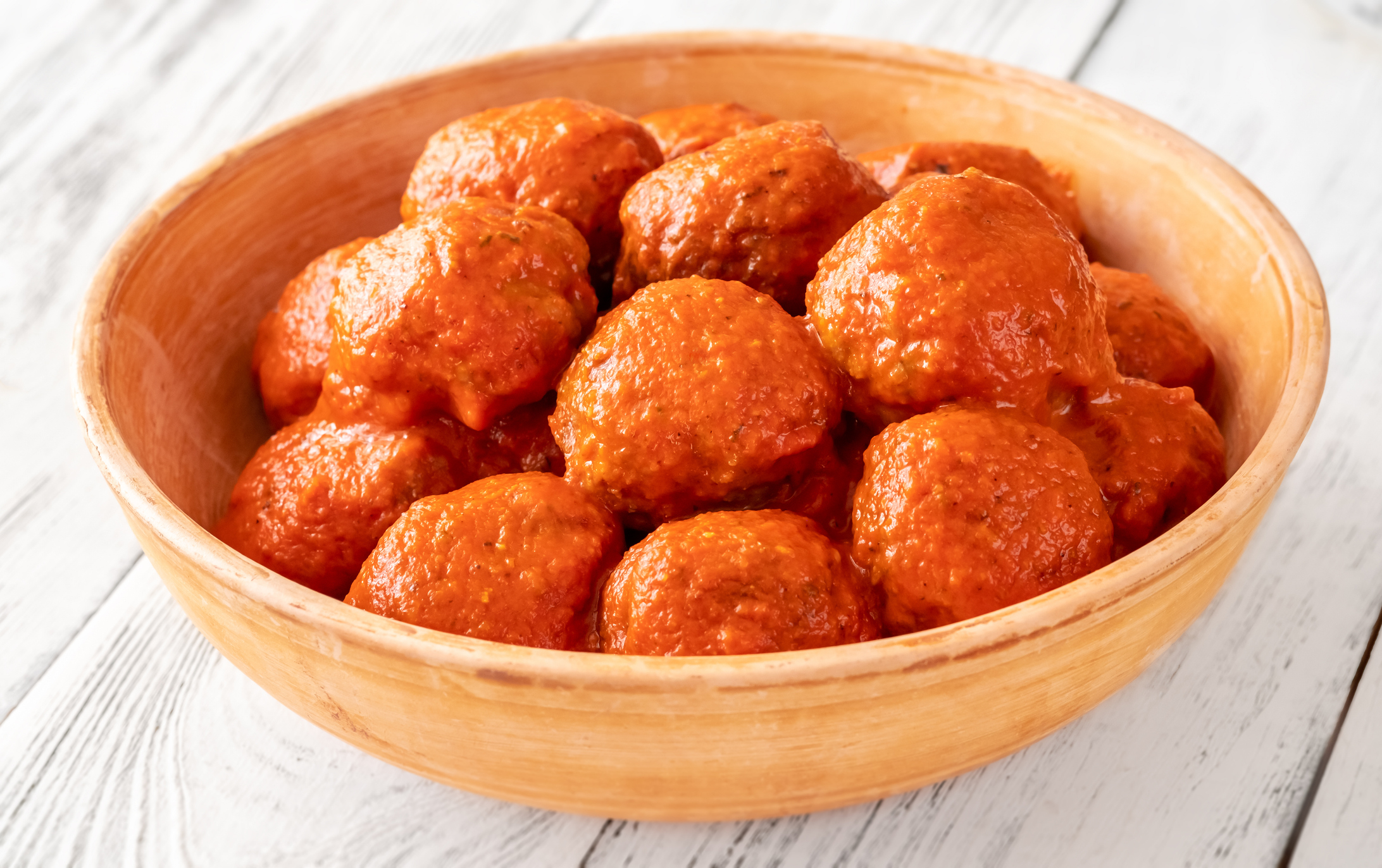A bowl filled with meatballs coated in sauce