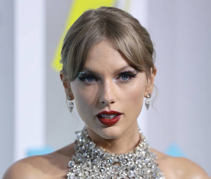 Taylor Swift with sparkling jewelry, dramatic eye makeup, and red lipstick