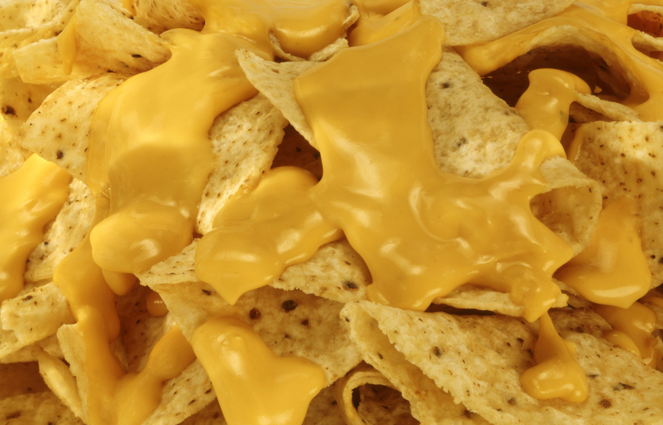 A close-up of nachos with melted cheese topping