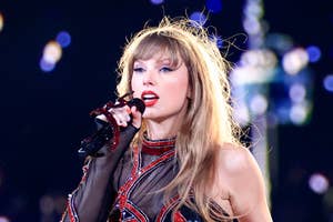 Taylor Swift performing on stage in a sparkling bodysuit with red designs