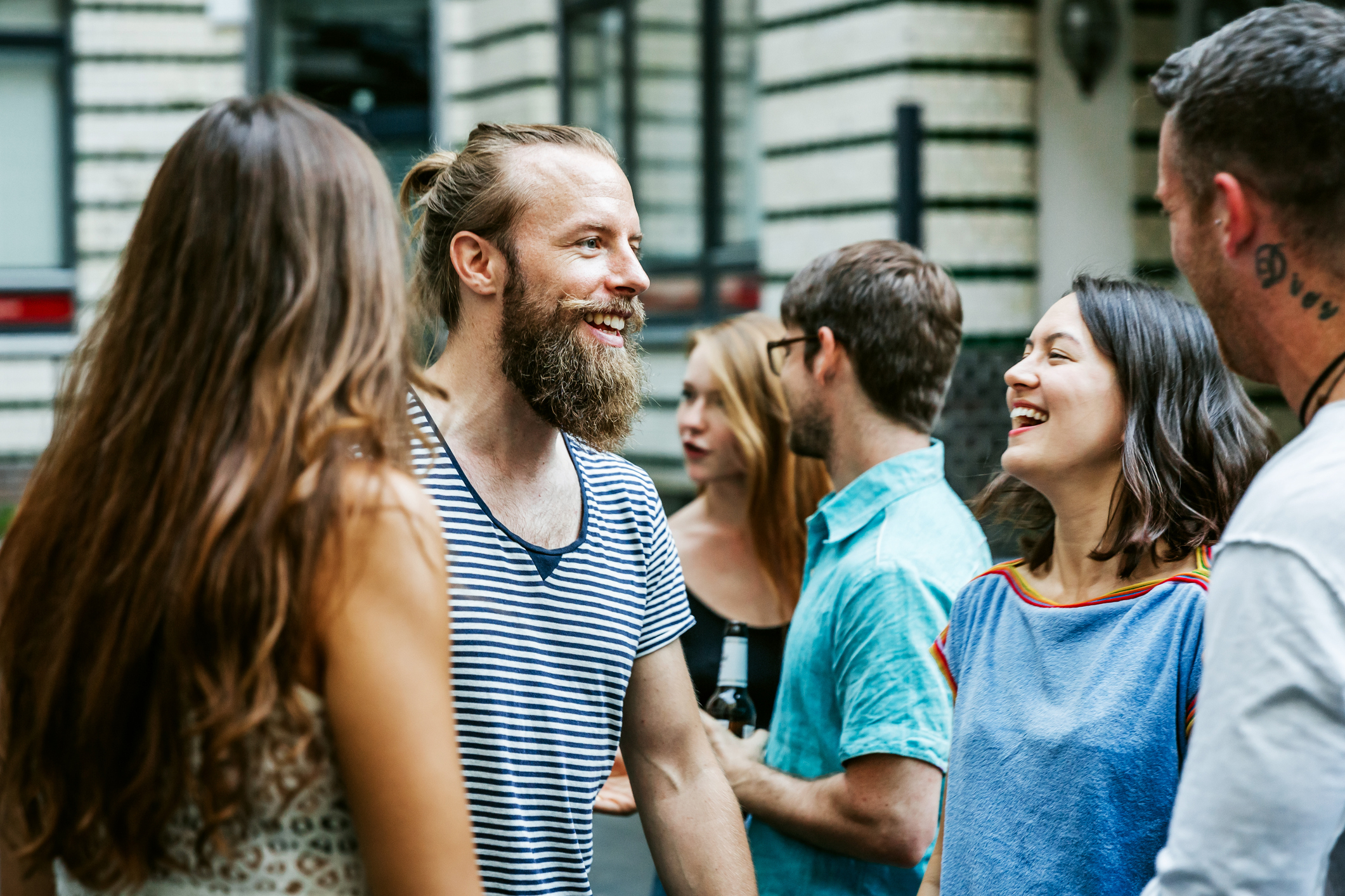 Group of people engaging in conversation at a social event, smiling and expressing positive body language