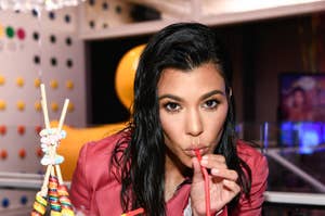 Kourtney Kardashian sips a drink at an event
