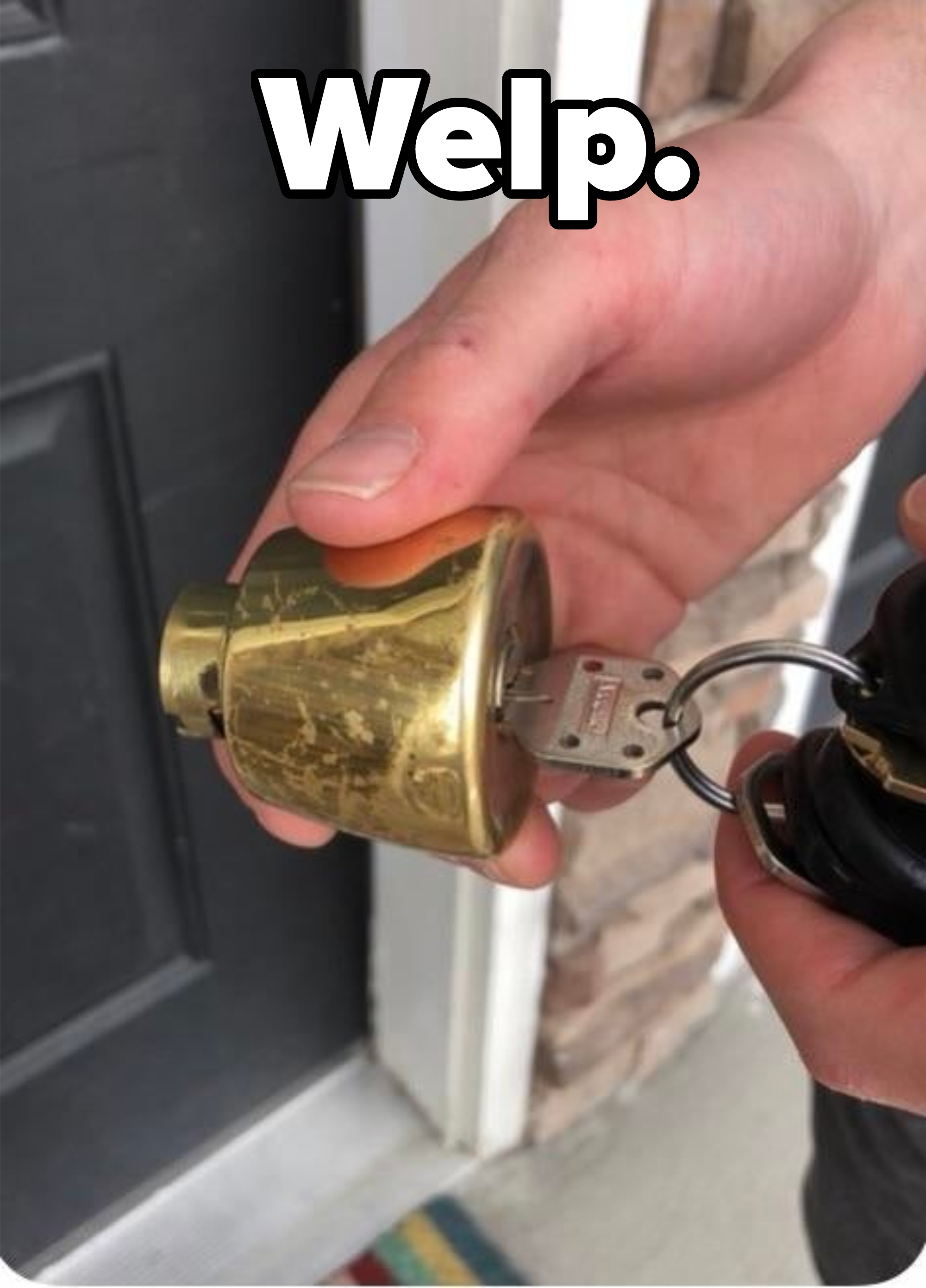 Hand holding a brass door knob and keys, with a door in the background
