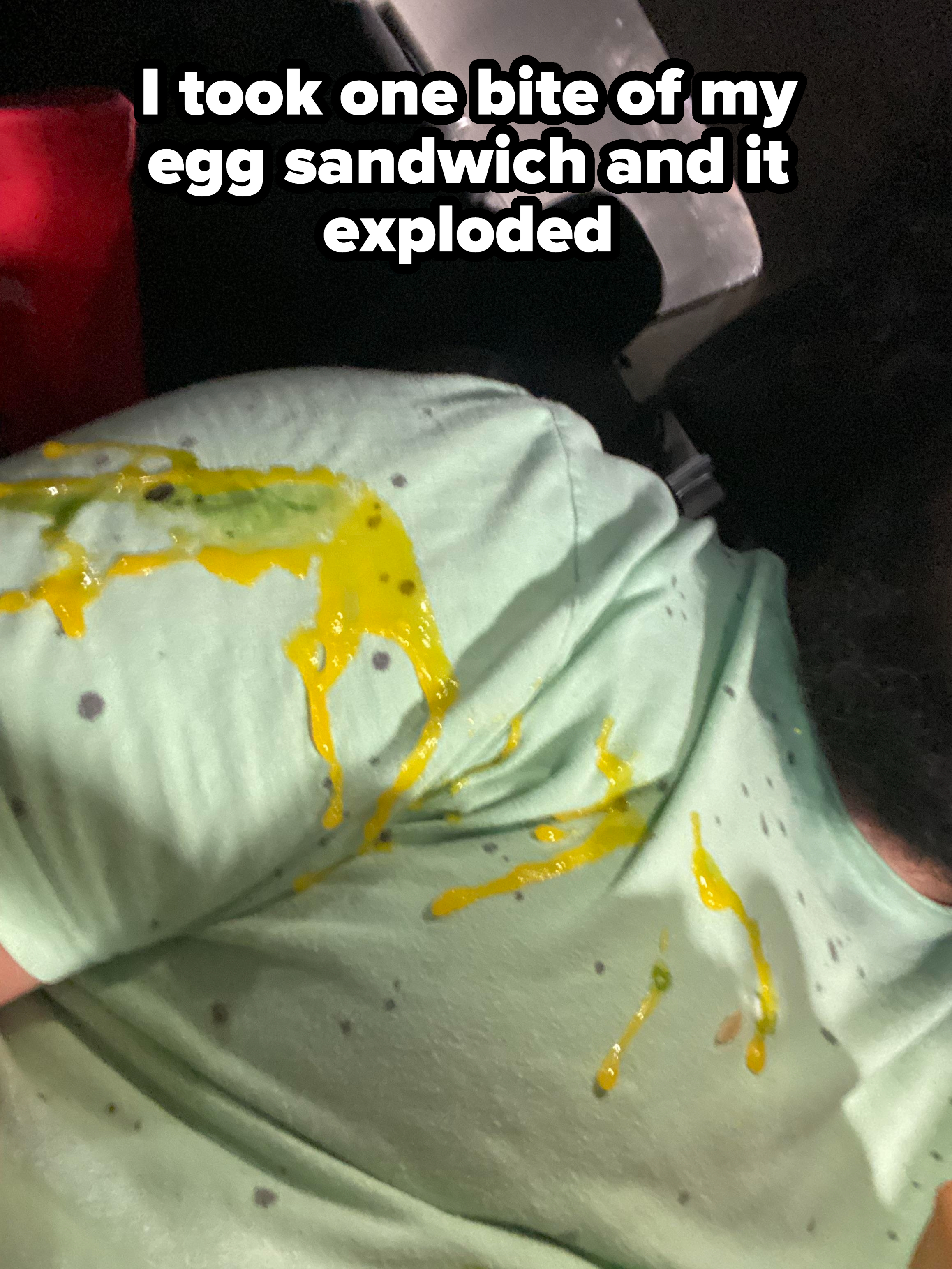 Person in a green shirt with a spilled condiment on it