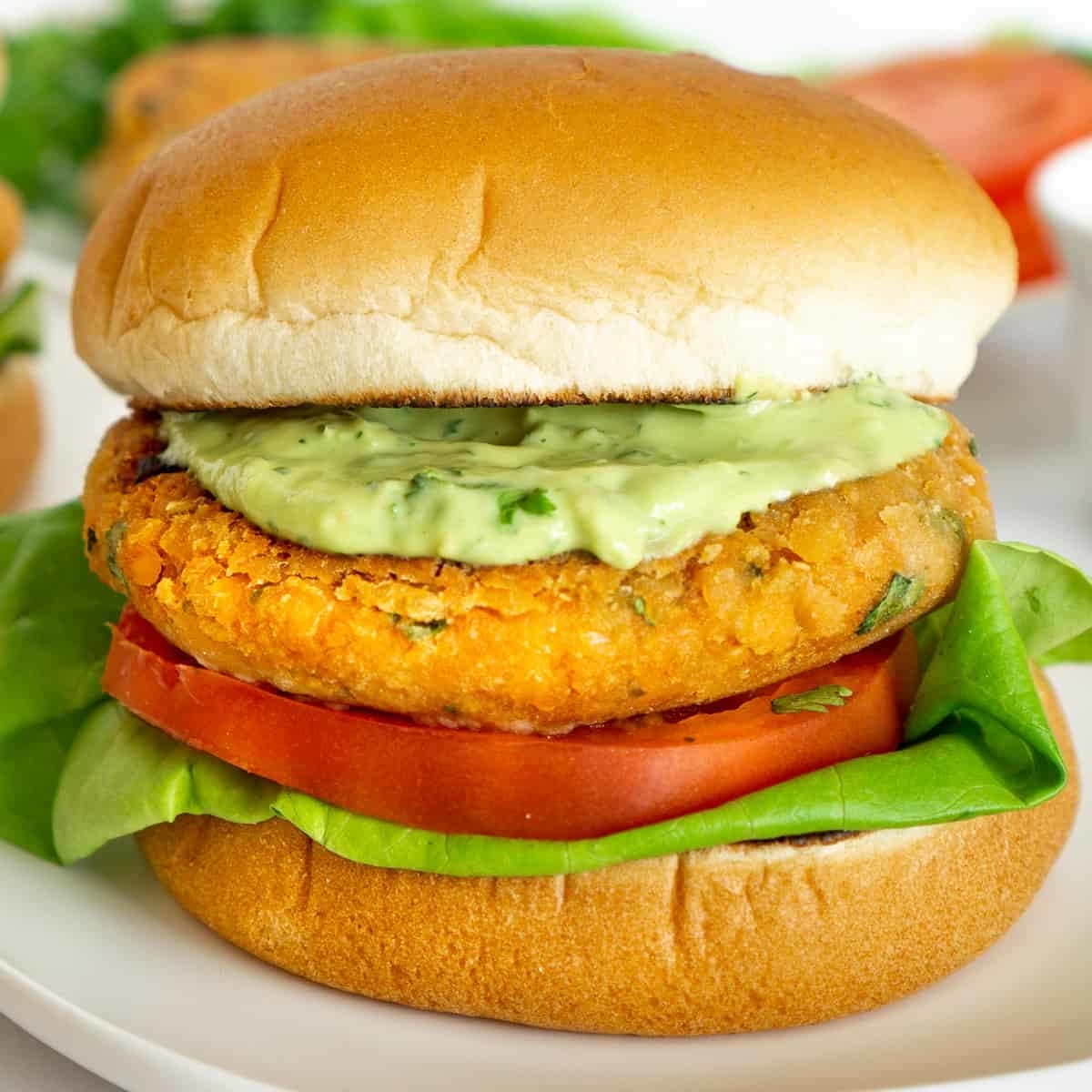 Veggie burger with a patty, lettuce, tomato, sauce, and bun