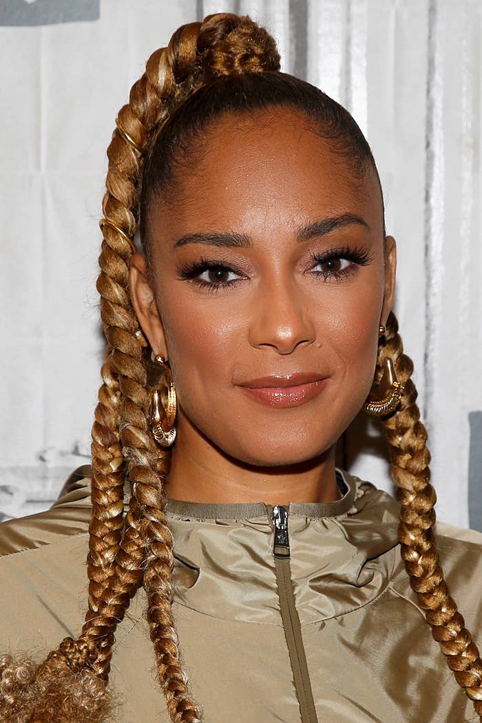 Amanda Seales wearing a taupe outfit with braided hair and hoop earrings