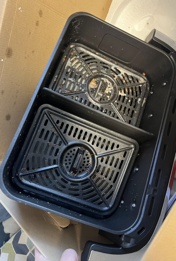 Burner covers in a container, appearing to be soaked for cleaning