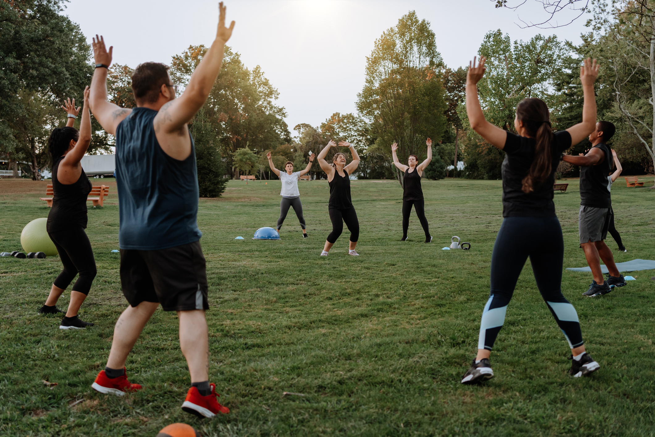 Group of people participating in an outdoor exercise class in a park