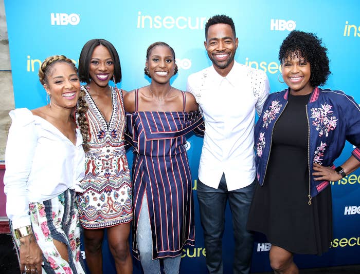 Five cast members from &#x27;Insecure&#x27; smiling at a promotional event, in stylish casual outfits