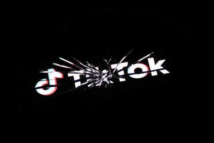 TikTok logo visible through cracked glass, symbolizing damaged screen or concept of social media vulnerability