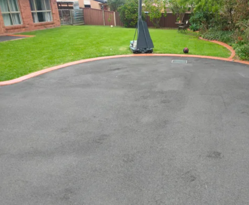 sealed asphalt driveway for house with lawn