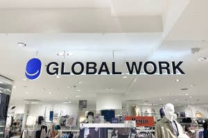 Sign reading "GLOBAL WORK" above clothing racks and mannequins in a retail store
