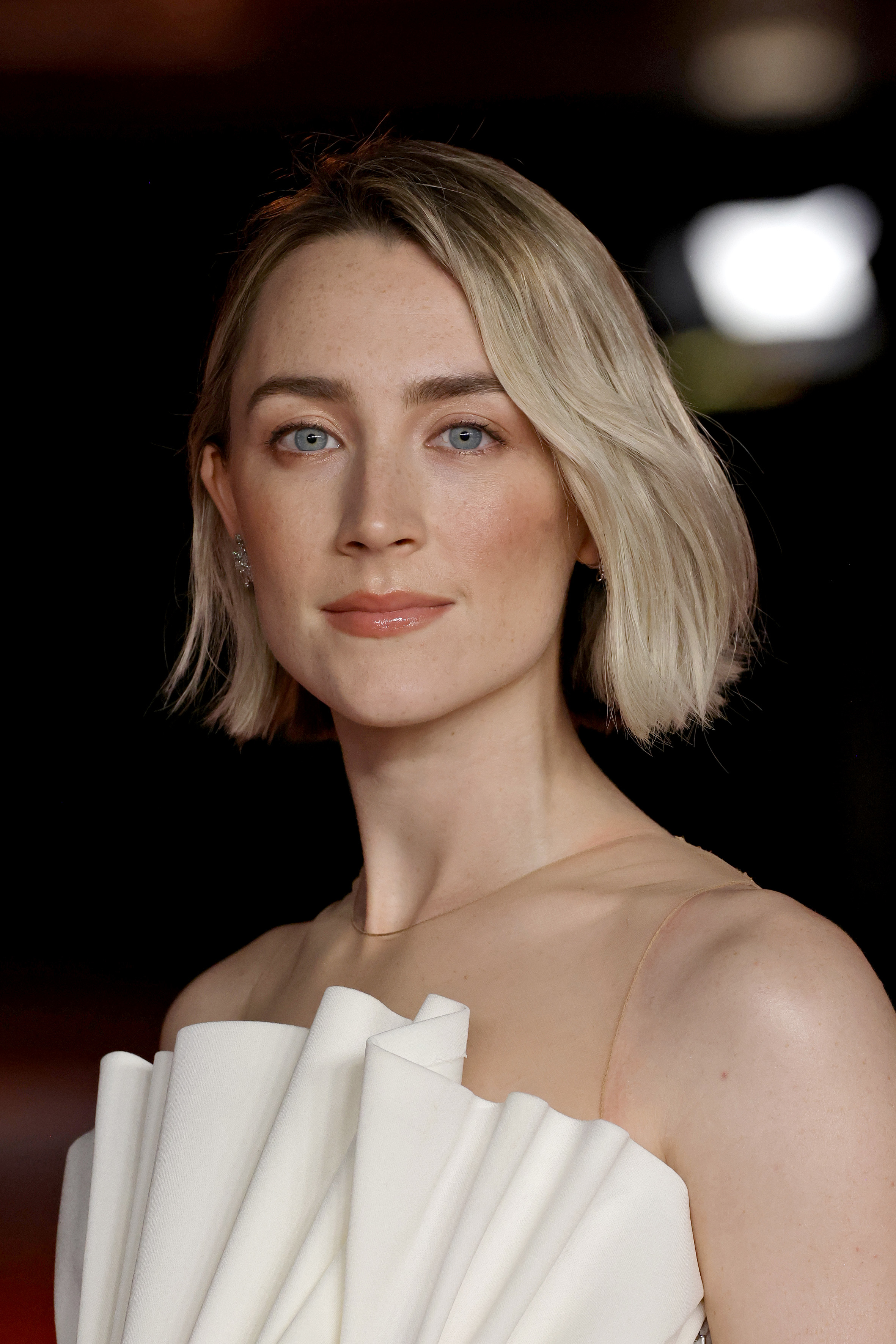 Saoirse Ronan wearing an elegant off-shoulder dress with pleat details at an event