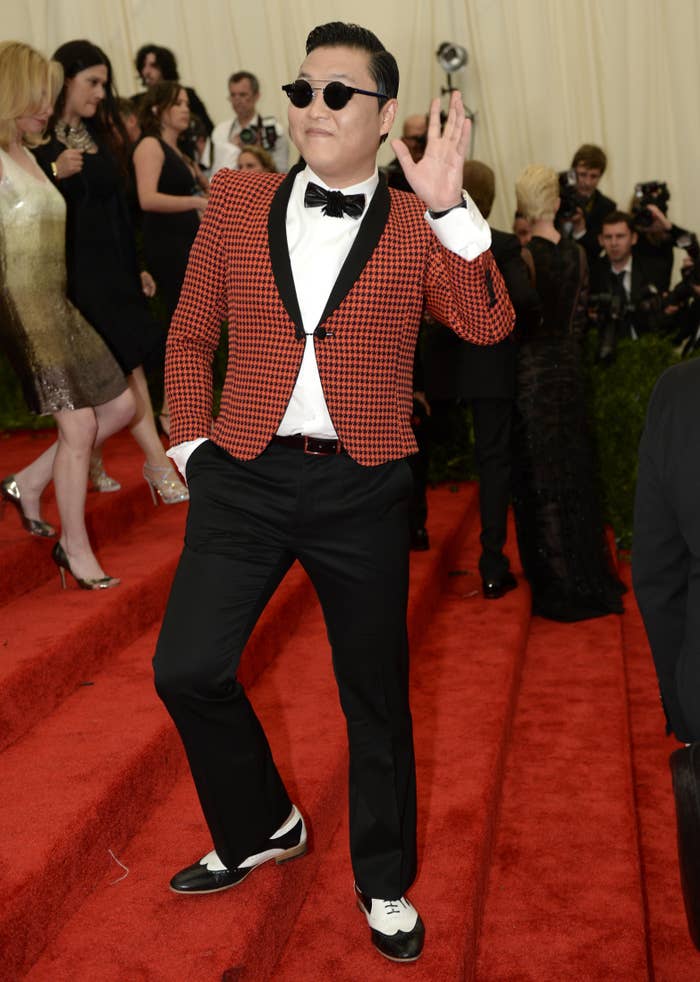 PSY en alfombra roja de la MET GALA 2013 con chaqueta estampada, pantalones negros, pajarita y gafas de sol