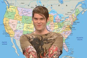 Person in a printed top with arms crossed standing before a map of North America