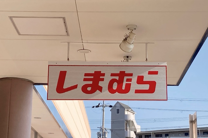 赤い看板に「しまむら」と白字で書かれています。