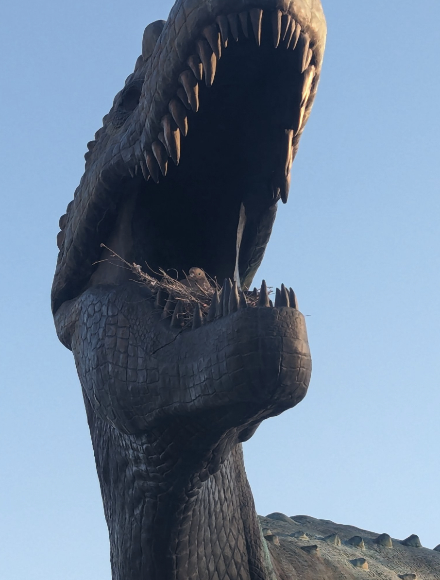 巨大な恐竜の彫刻が口を大きく開けている様子。