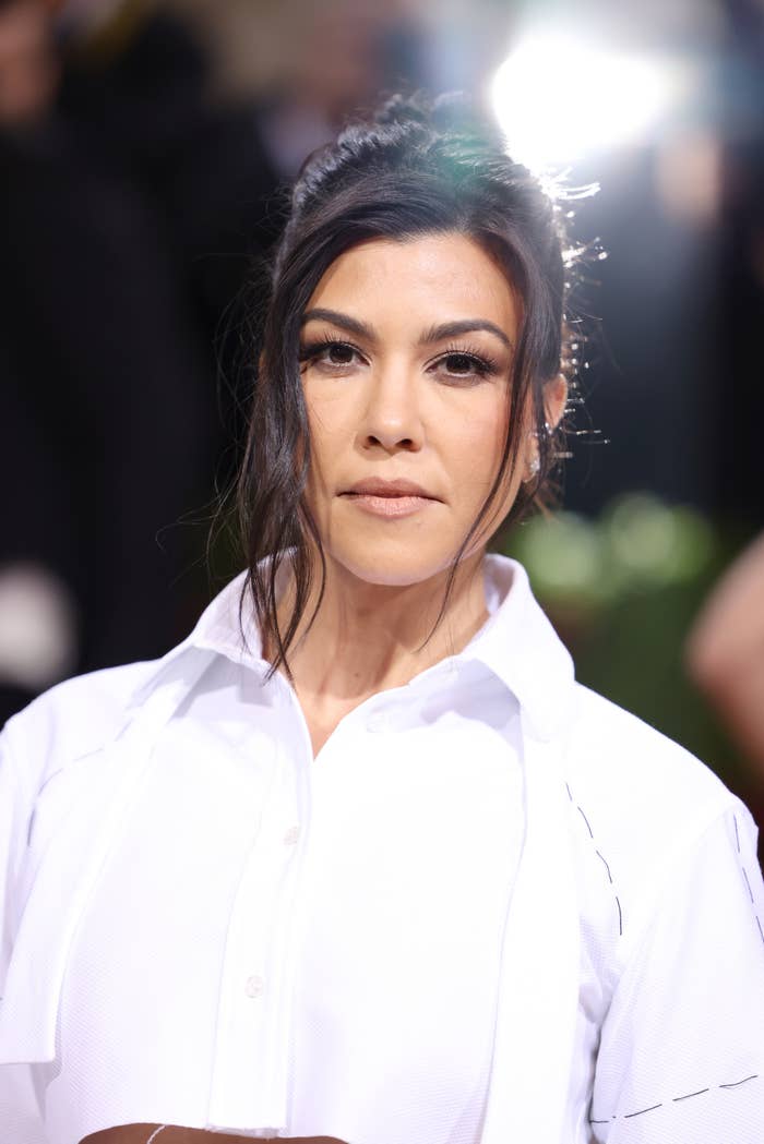Close-up of Kourtney Kardashian in a white shirt with an updo hairstyle
