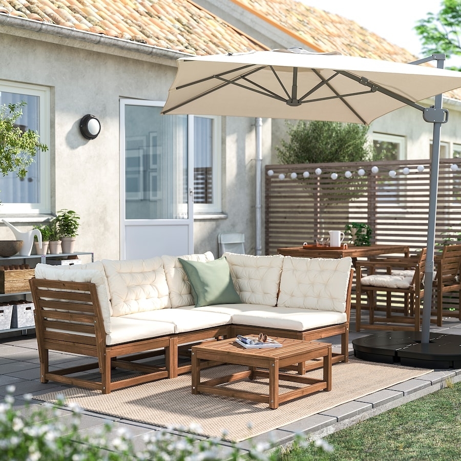 Outdoor furniture set with a sofa, chairs, and a patio umbrella in a backyard setting