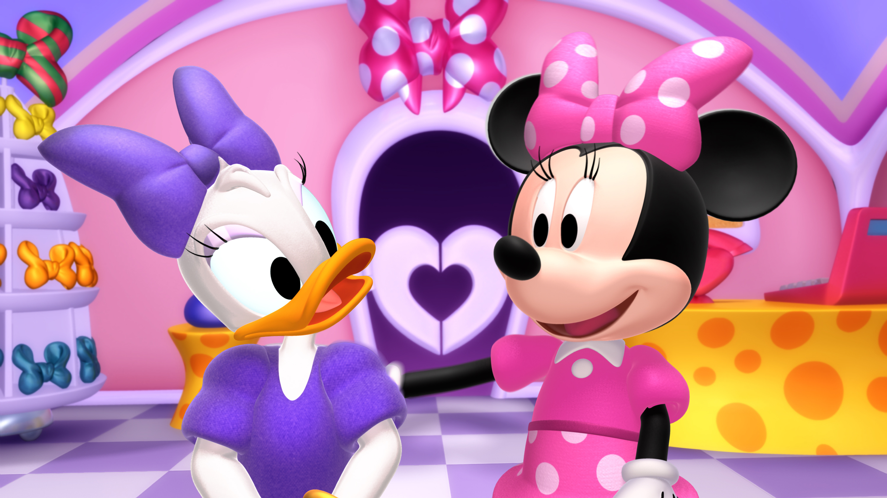Animated characters Daisy Duck and Minnie Mouse standing in a colorful cartoon room with heart decorations