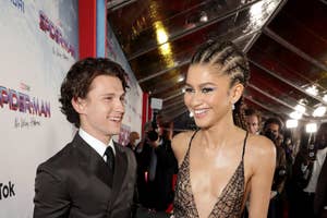 Tom Holland and Zendaya in elegant attire at a Spider-Man movie premiere