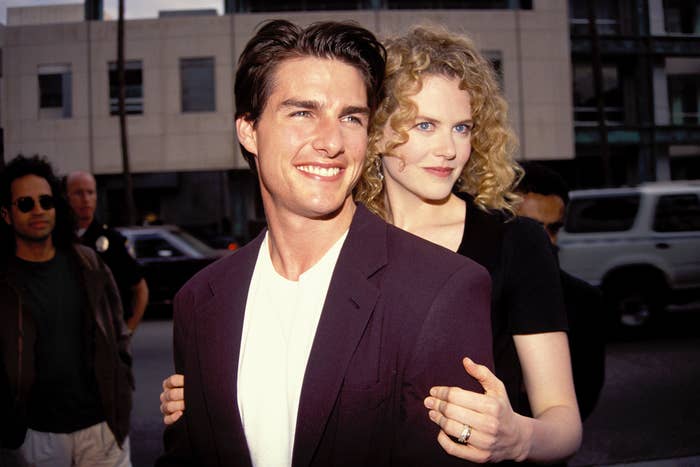 Tom Cruise in a suit and Nicole Kidman in a dress smiling at an event