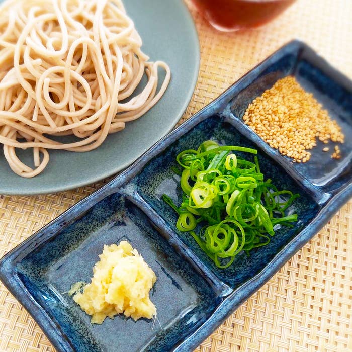 そば、ねぎ、しょうが、ごまが並んだ料理の写真です。