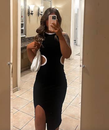 Person successful a achromatic cut-out formal holding a achromatic container posing for a reflector selfie