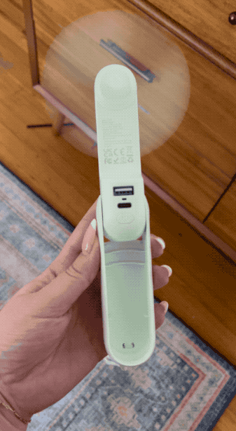 Hand holding a portable pregnancy test displaying a positive result
