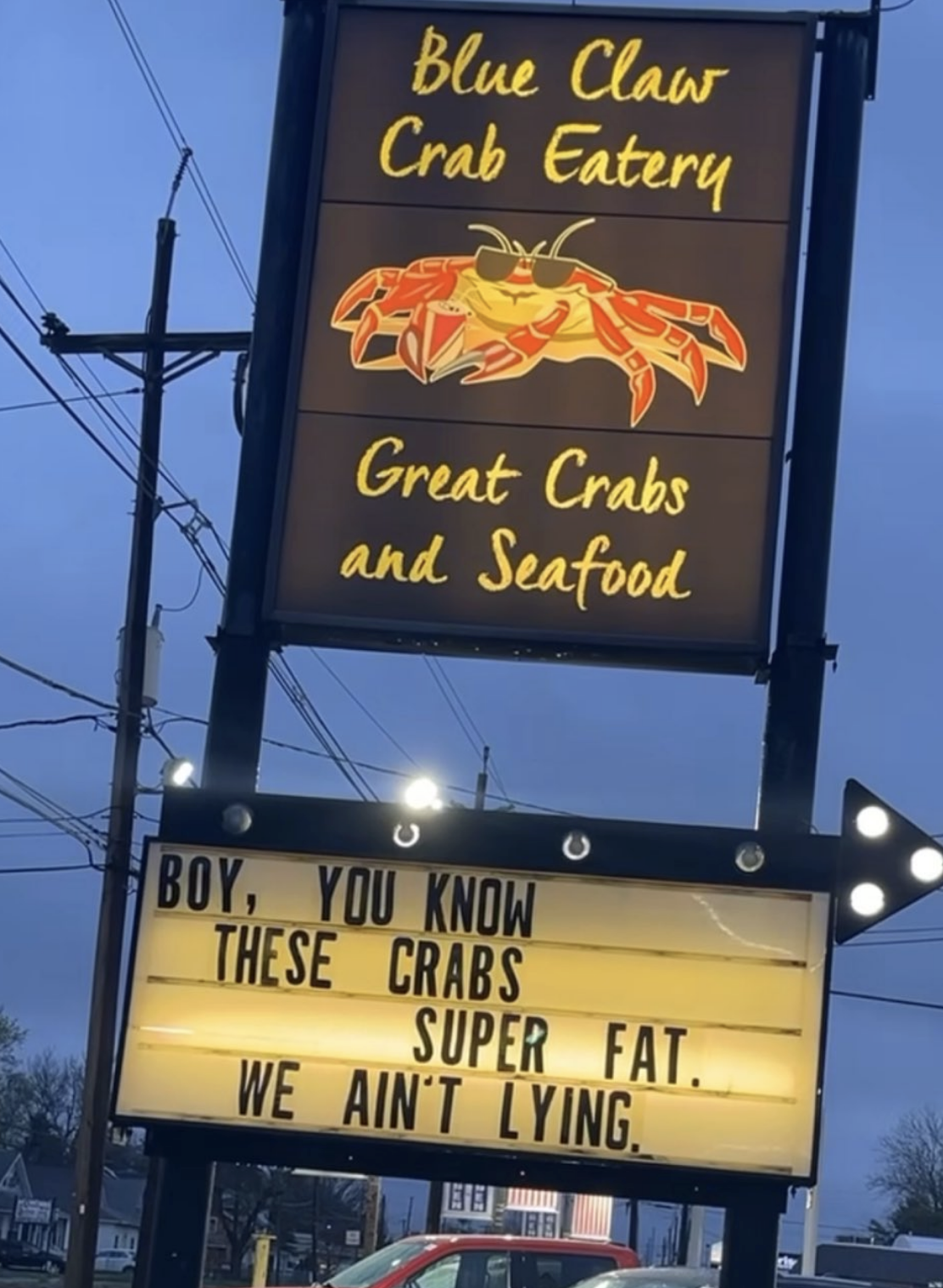 Signboard for Blue Claws Crab Eatery advertising &quot;Great Crabs and Seafood&quot; with a humorous message that says, &quot;Boy, you know these crabs super fat. We ain&#x27;t lying&quot;