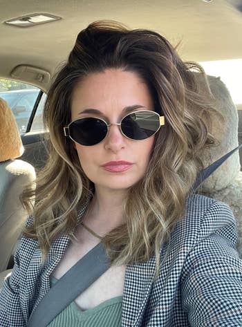 reviewer in car wearing sunglasses and a plaid jacket