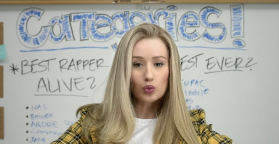 Woman in front of a whiteboard with the title &quot;Categories&quot; and a list including &quot;Best Rapper Alive?&quot; with rapper names