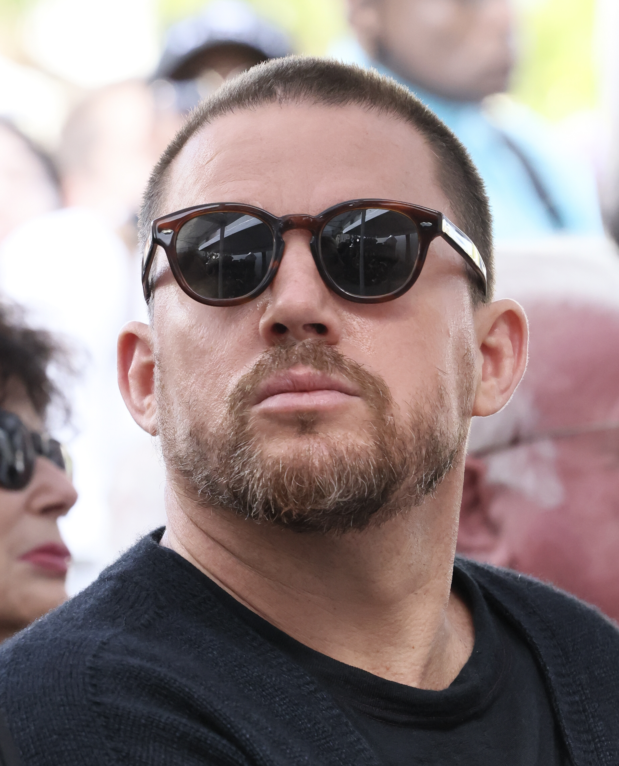 Close-up of Channing Tatum wearing sunglasses and a casual sweater at an outdoor event