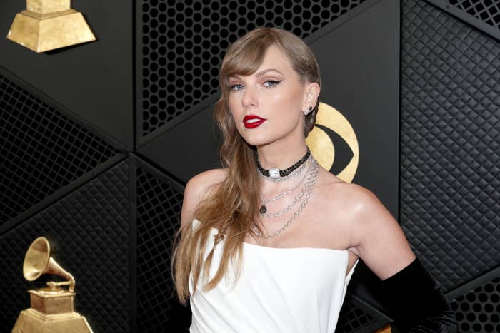 Taylor Swift in a white off-shoulder gown with layered necklaces at the Grammys