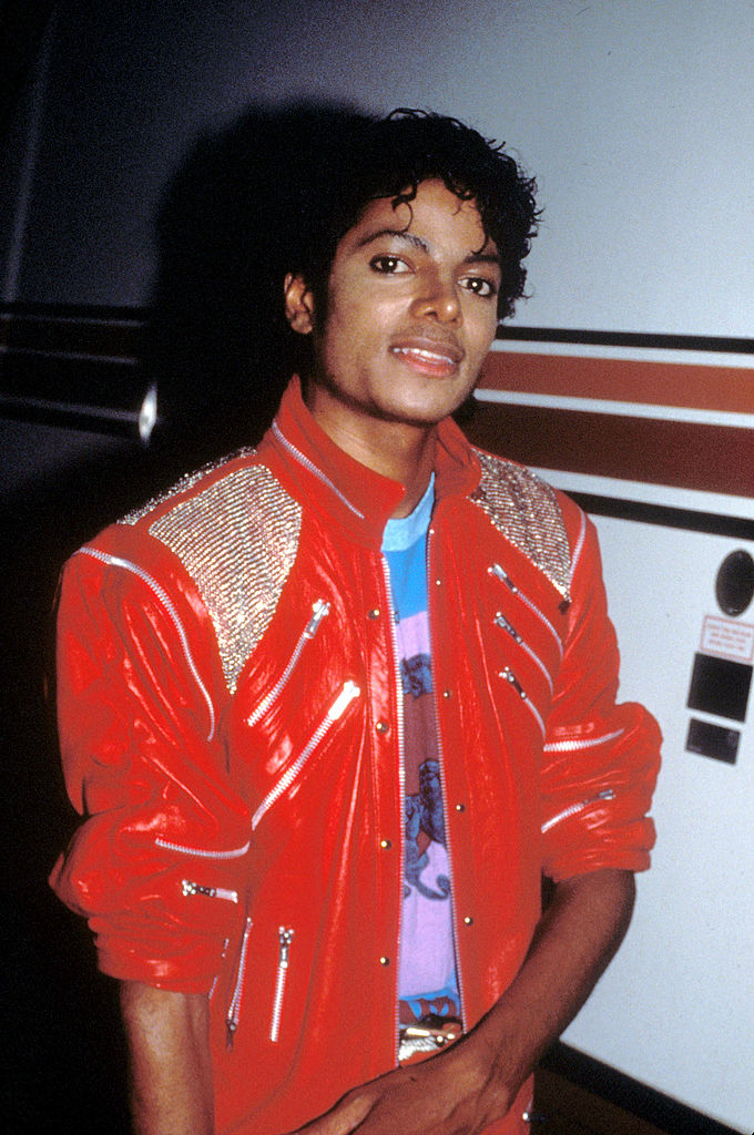 Michael Jackson in a red jacket with embellishments, posing for the camera