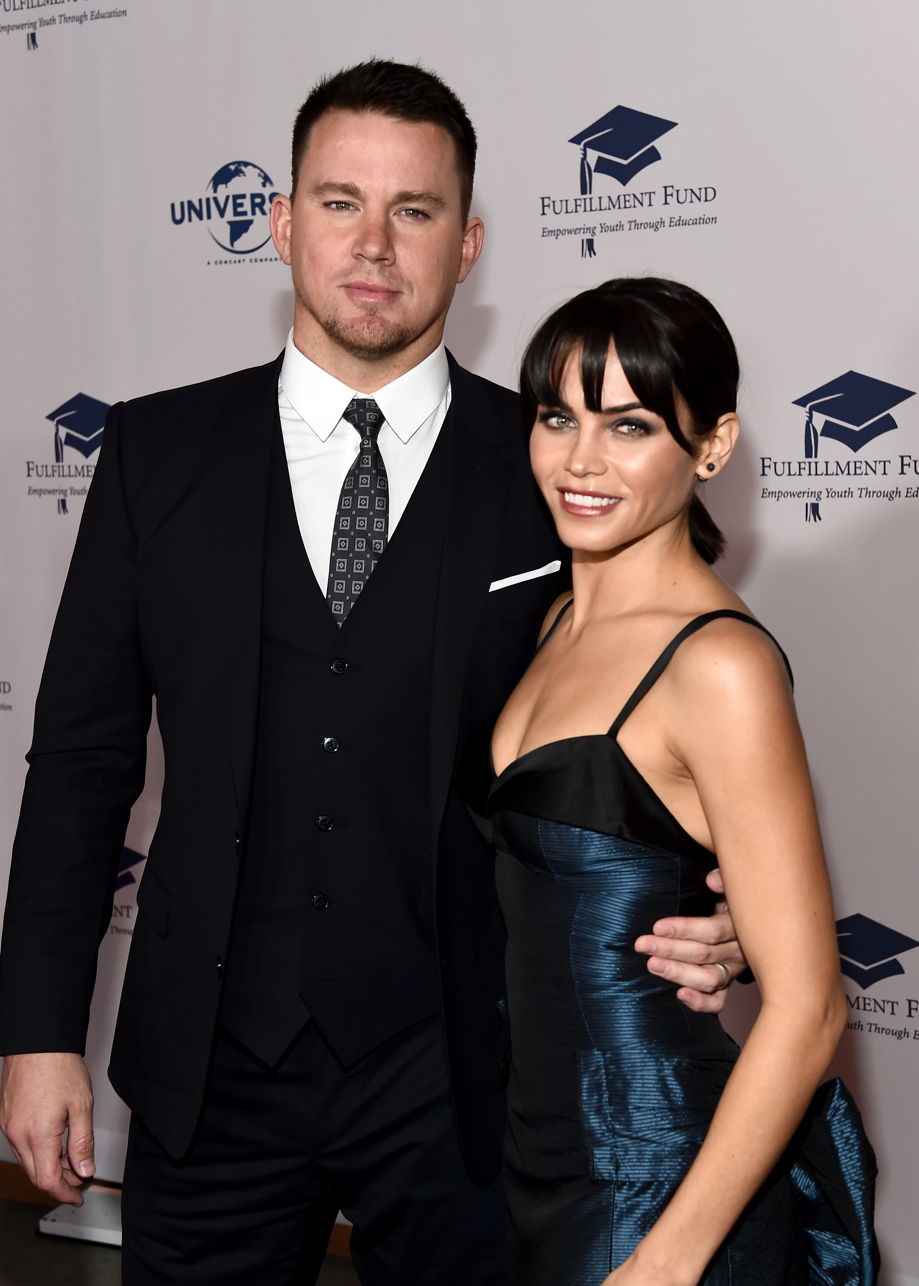 Channing Tatum in a black suit and Jenna Dewan in a strapless dress posing at an event
