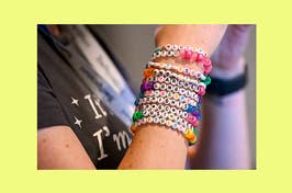 Arm wearing a bunch of beaded eras tour bracelets