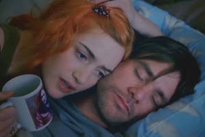Clementine snuggles up to a sleeping Joel, expressing concern in a scene from the film "Eternal Sunshine of the Spotless Mind."