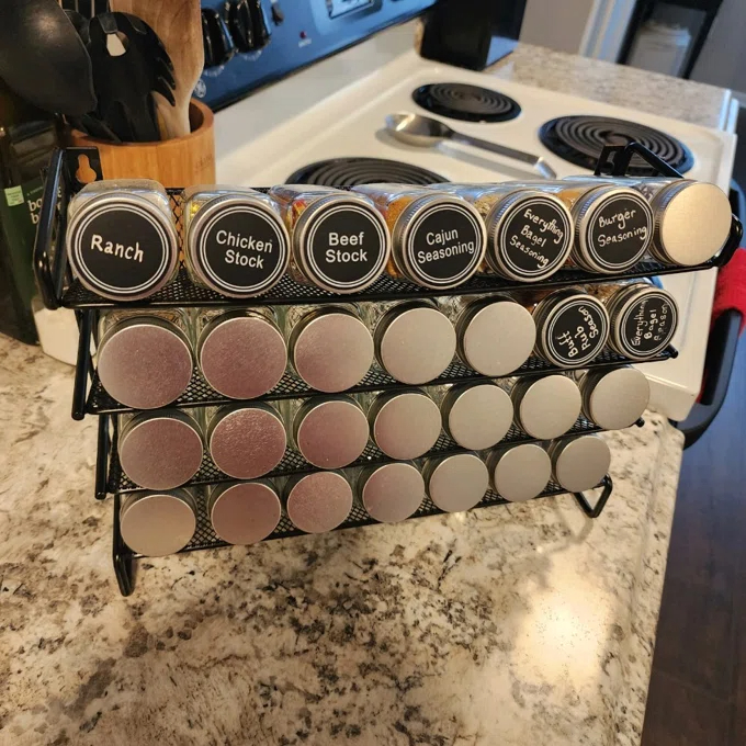 Reviewer&#x27;s photo of the spice rack with labeled jars for ranch, chicken and beef stock, Cajun seasoning, and others on a kitchen counter