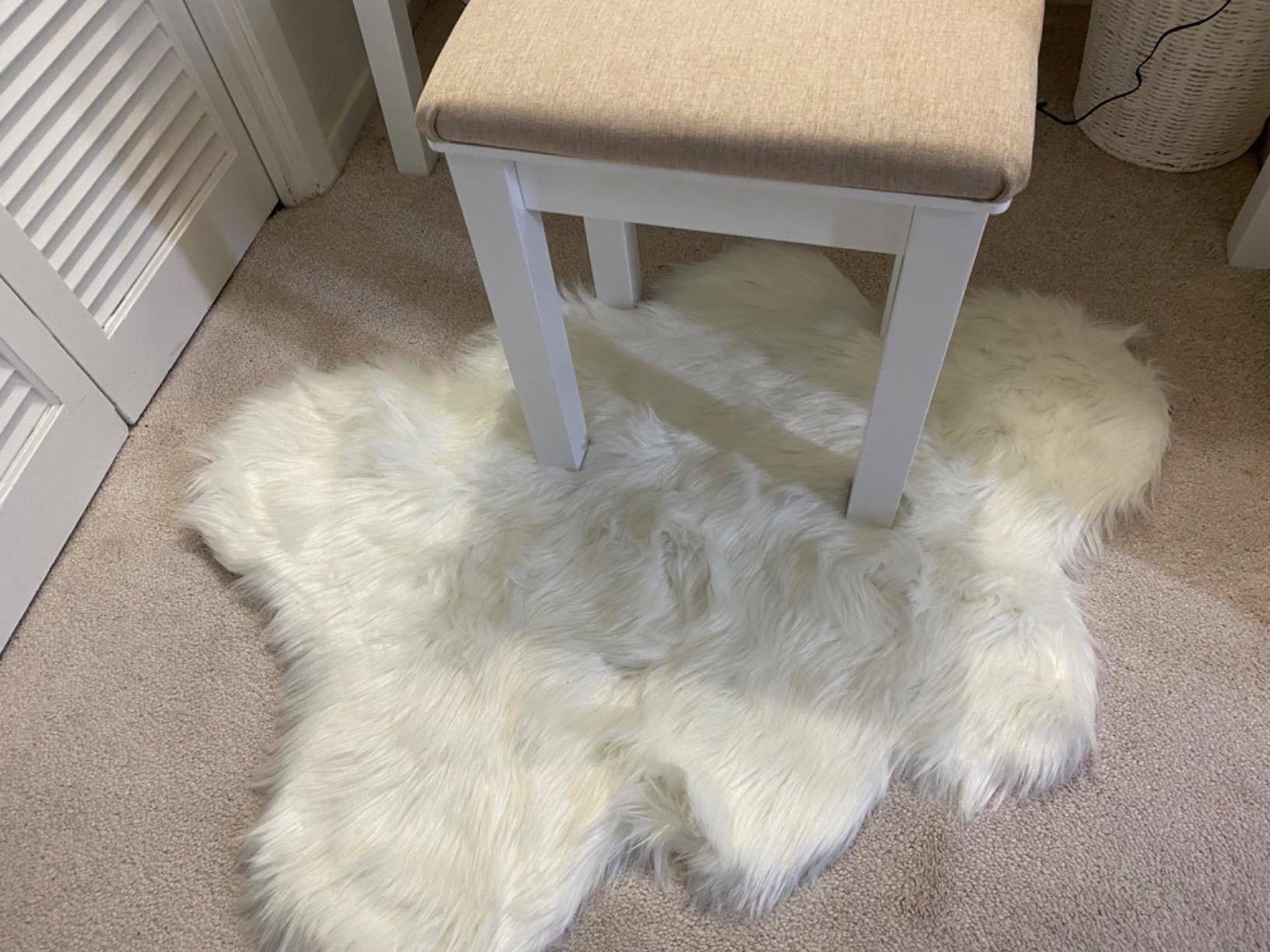A stool connected  a achromatic  faux fur rug, perfect  for a cozy interior buying  theme