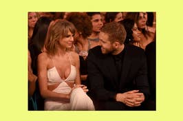 Taylor Swift and Calvin Harris seated side by side at an awards show, smiling at each other