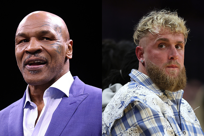 Mike Tyson in a purple suit and Jake Paul in a patterned white outfit at an event