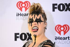 Person with face painted like a star, black outfit with sparkles, at iHeart Radio event