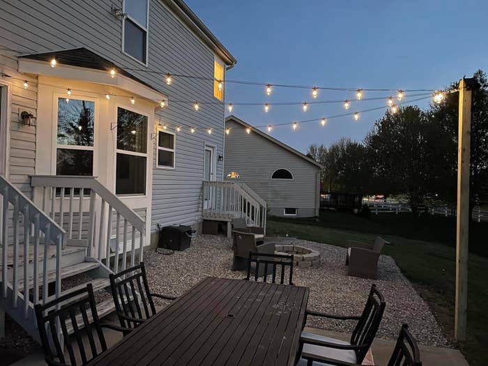 String lights hanging over a backyard patio set at dusk, enhancing outdoor ambience for shopping inspiration