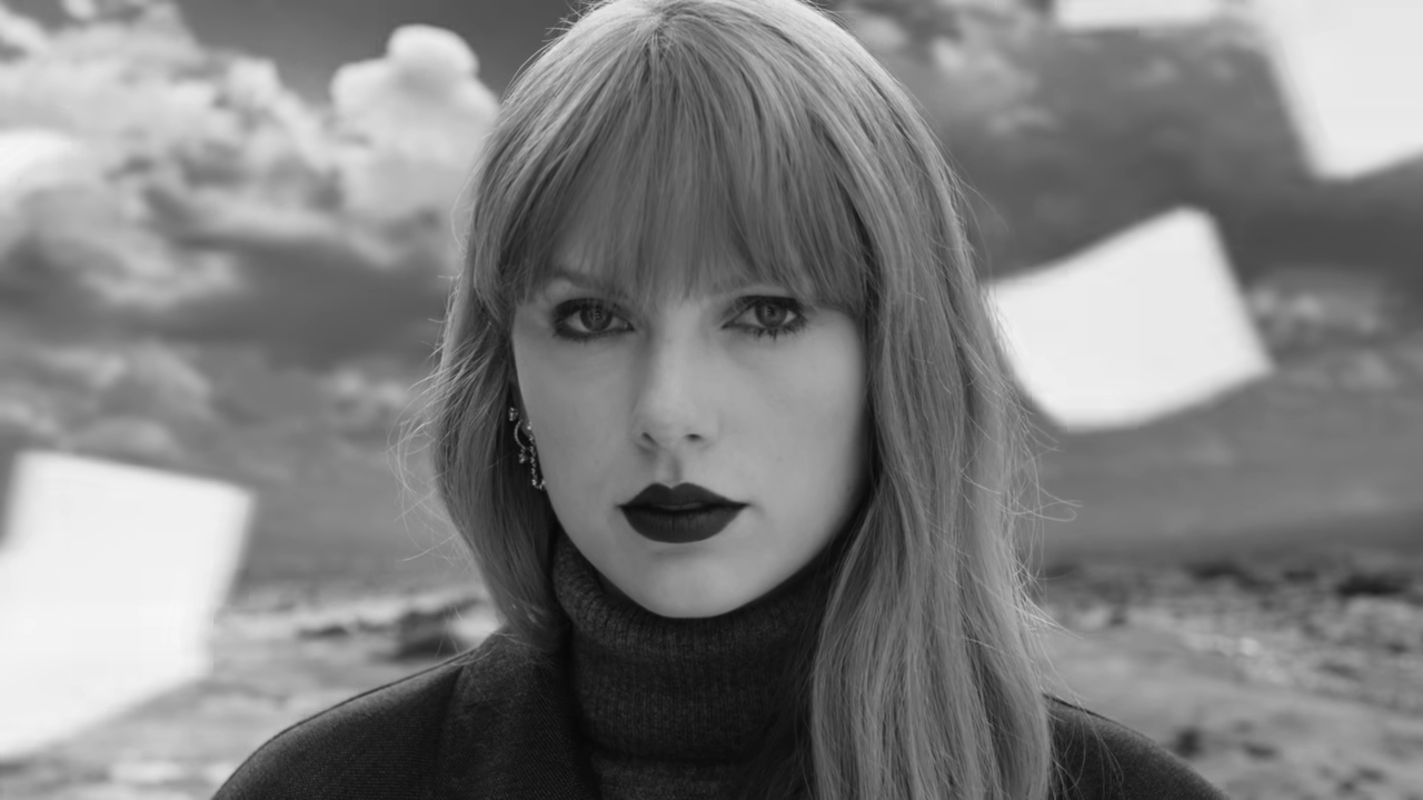 Person with bangs and turtleneck, bold lipstick, looking at camera